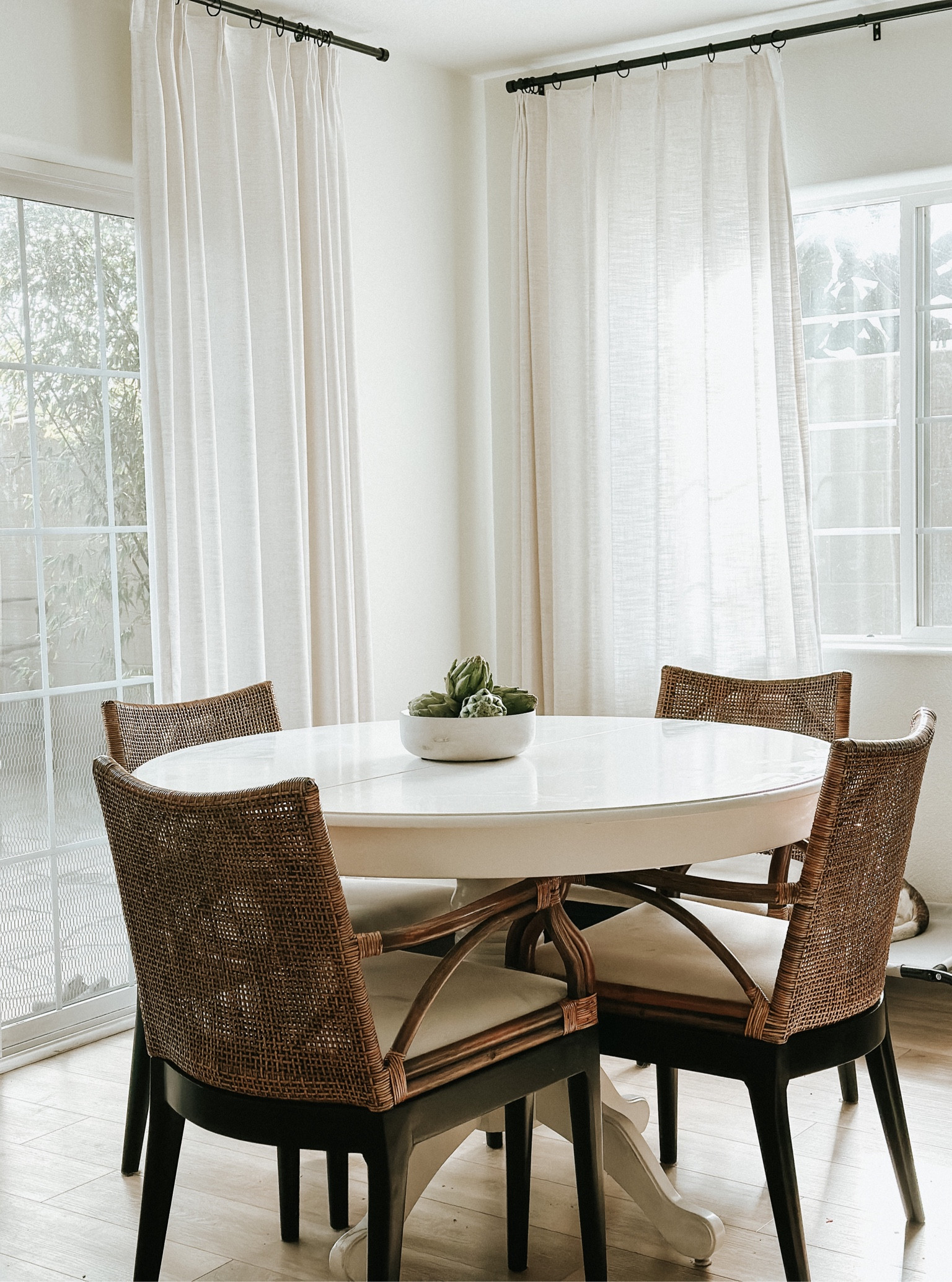Dining room light so pretty this time of the day, white round table and coastal chairs super comfortable and easy to keep clean 