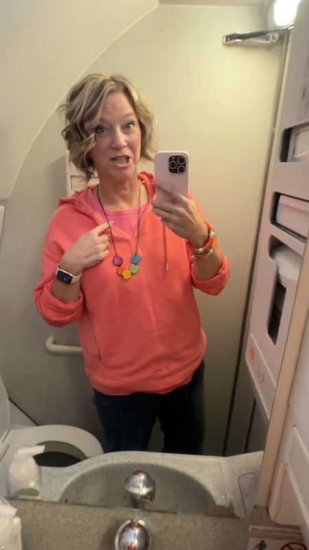 Airplane travel outfit idea: pink and coral, bracelet stack with bright colors. #traveloutfit #airplaneoutfit 

#LTKover40 #LTKstyletip #LTKtravel