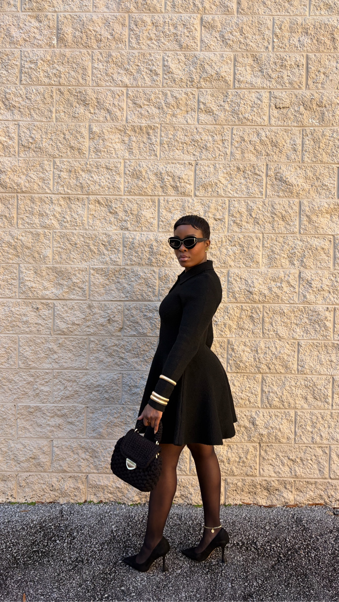 Black skater dress, winter fashion, chic black and gold outfit, black mini dress, gold bangles, knitted black purse