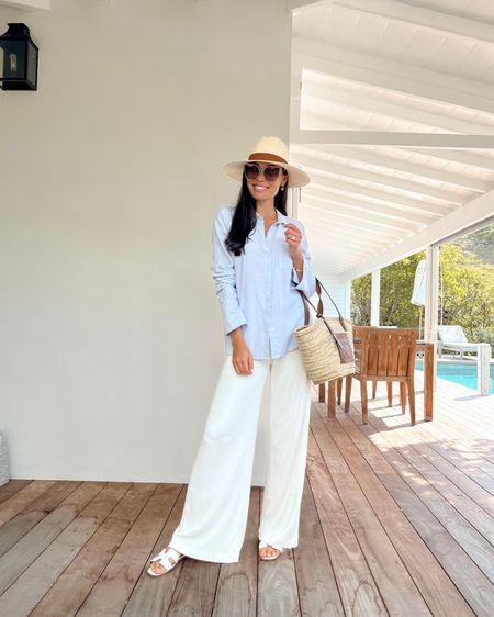 Kat Jamieson wears a white wide leg pant, blue striped button down shirt, Panama straw hat, and straw tote with Hermes sandals in St. Barths. Classic style, travel, vacation, spring break, summer, chic. 

#LTKSeasonal #LTKtravel #LTKitbag