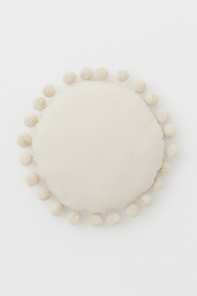 Round cushion in cotton canvas with pompom trim. Polyester fill. | H&M (US + CA)