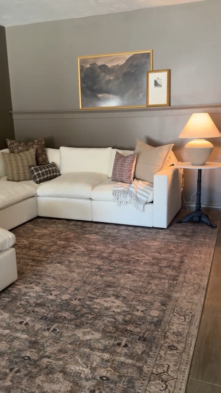 The perfect teddy bear brown paint color doesn’t exiii… oh but it does! 🐻 I chose BM Stampede for my basement living room and it is so cozy down here for movie nights! Follow along @ourmountainsidehome_1 for diy, home renovation and home styling!  Brown paint color, paint in the can, basement makeover, movie room, cozy home, sectional, modular sectional, cozy vibes.  #benjaminmoore #brownpaint #basementmakeover #movieroom #livingroom