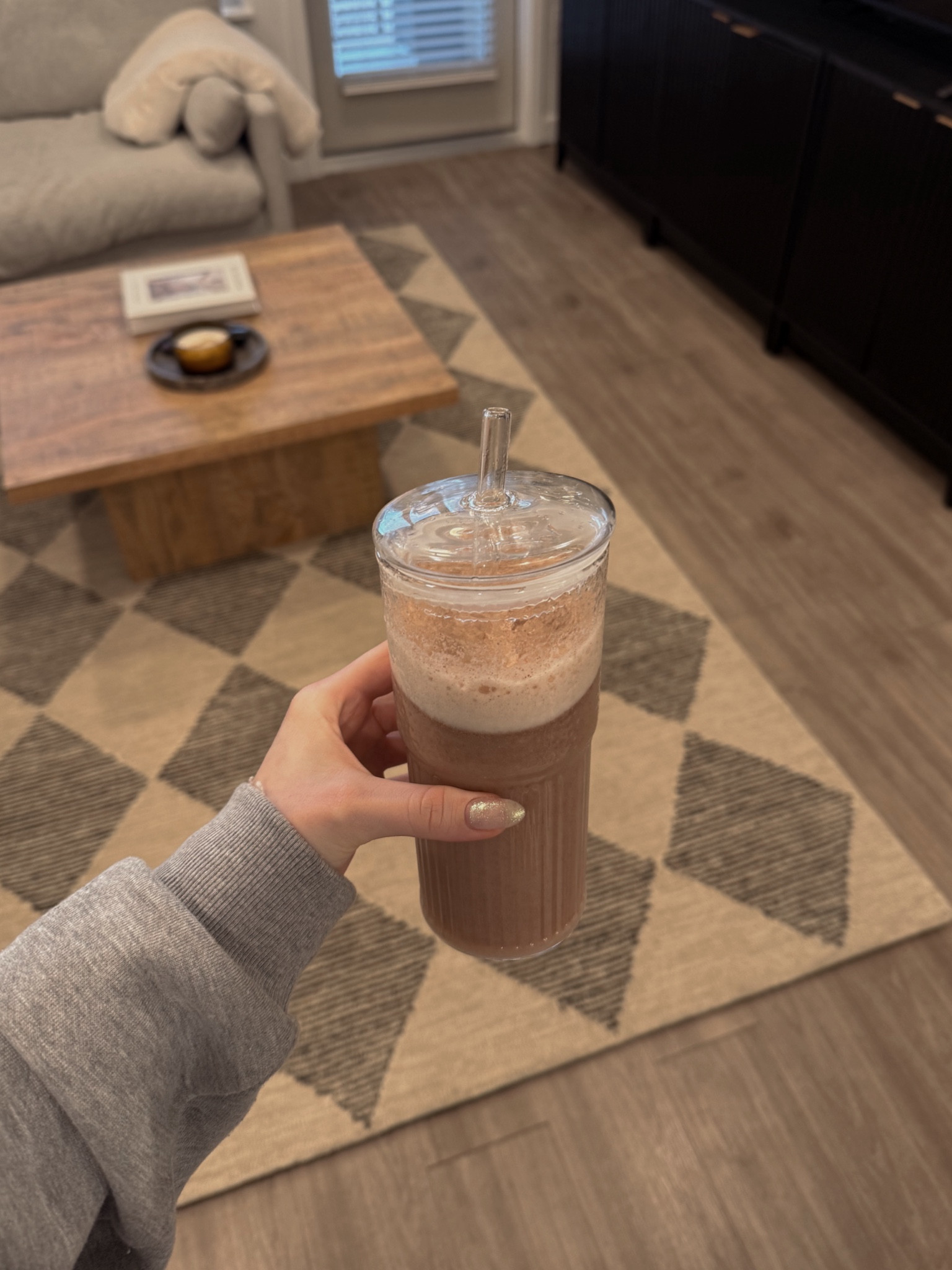 Glass tumbler, diamond checkered rug, wood coffee table
