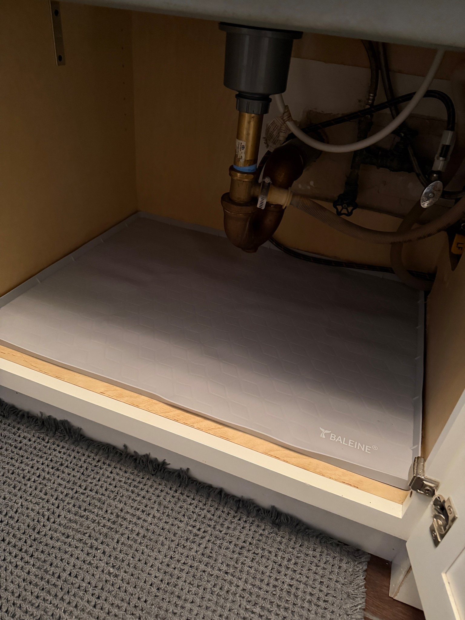 Under the sink mat to prevent water damage from leaks
