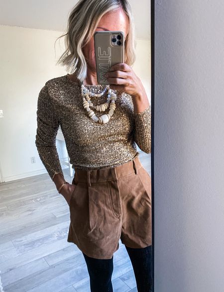 I can think of more than several opportunities/ ways to wear this sequin long sleeve tee.  But let’s start with these faux suede shorts, some black tights, some booties and a statement necklace. 
This sequin tee comes in a lot of color options, I’m in the gold, in my true size.

#LTKstyletip #LTKHoliday #LTKunder100
