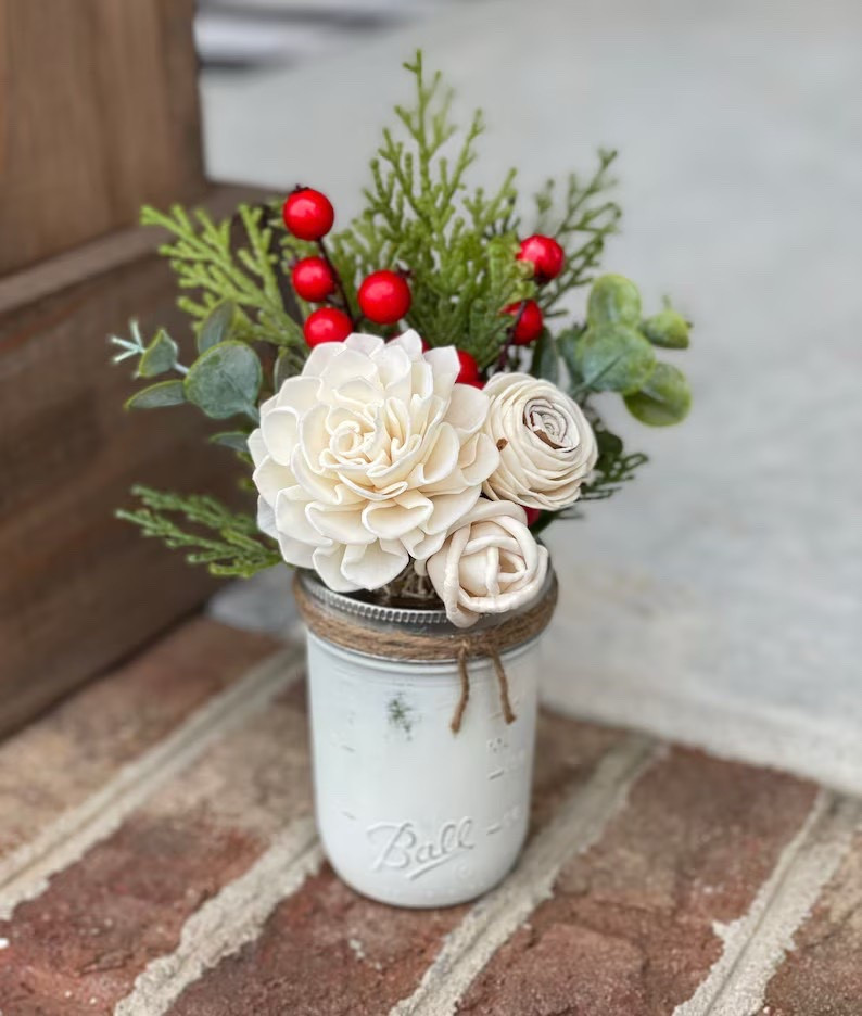 Spread holiday joy with this Christmas Mason Jar Arrangement by HaveHopeDesigns! 🎄✨ Handcrafted in North Carolina, this charming piece features a mix of ivory and weathered wood-colored flowers accented with cedar, eucalyptus, and festive winter berries—all arranged in a distressed, cream-painted mason jar tied with jute ribbon. Perfect for gifting teachers, neighbors, or friends, or for adding a cozy farmhouse touch to your own home. A timeless holiday accent that brings cheer year after year! ❤️

#ChristmasDecor #HolidayGiftIdeas #FarmhouseStyle #RusticChristmas #FauxFlorals #EtsyFinds #HaveHopeDesigns #LTKHolidayHome #LTKSeasonalDecor

#LTKHome #LTKFindsUnder50 #LTKSeasonal