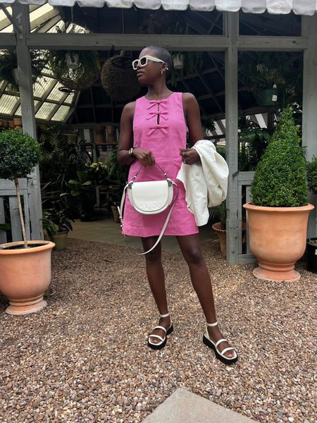 Casual Wedding guest dress or  Casual dinner outfit! Pink shift dress with front bow details, white double strap sandals, white Ganni purse and white square sunglasses. 

#LTKunder100 #LTKwedding #LTKitbag