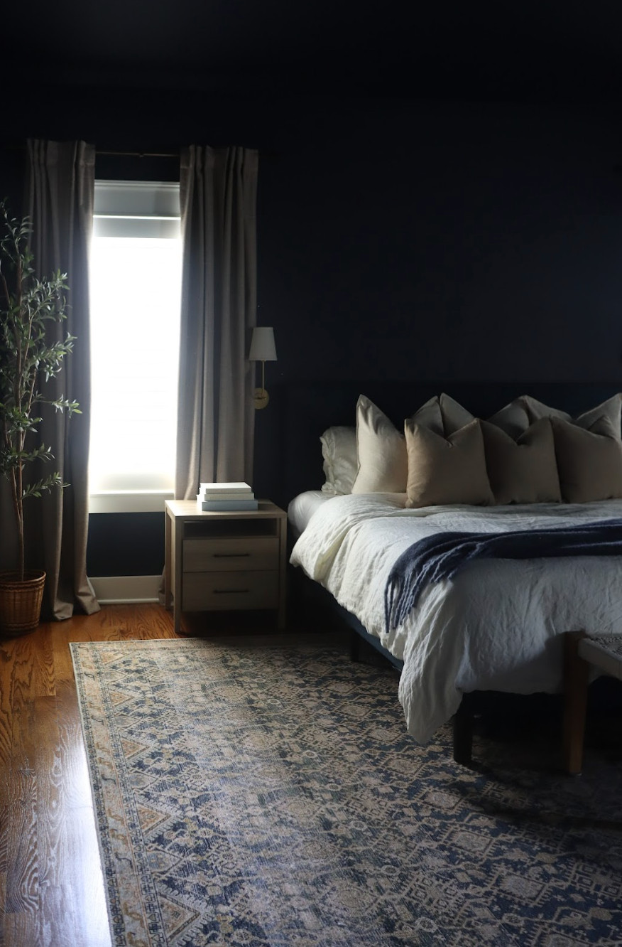 This primary bedroom makeover is proof that bold color can still feel cozy and balanced.✨ The couple wanted a space that felt organic and relaxed—neither too feminine nor too masculine—so we started by color drenching the walls in Naval by Sherwin Williams, a deep, moody navy that set the tone for the entire room. We kept their existing pieces, including the dresser, side tables, and bed frame, and layered in soft bedding, light drapery, and warm textures for contrast. The finished space feels both refreshed and familiar—a perfect mix of cozy and refined.💙 

 #bedroommakeover #colorfulinteriors #cozystyle #LTKHome #LTKFamily