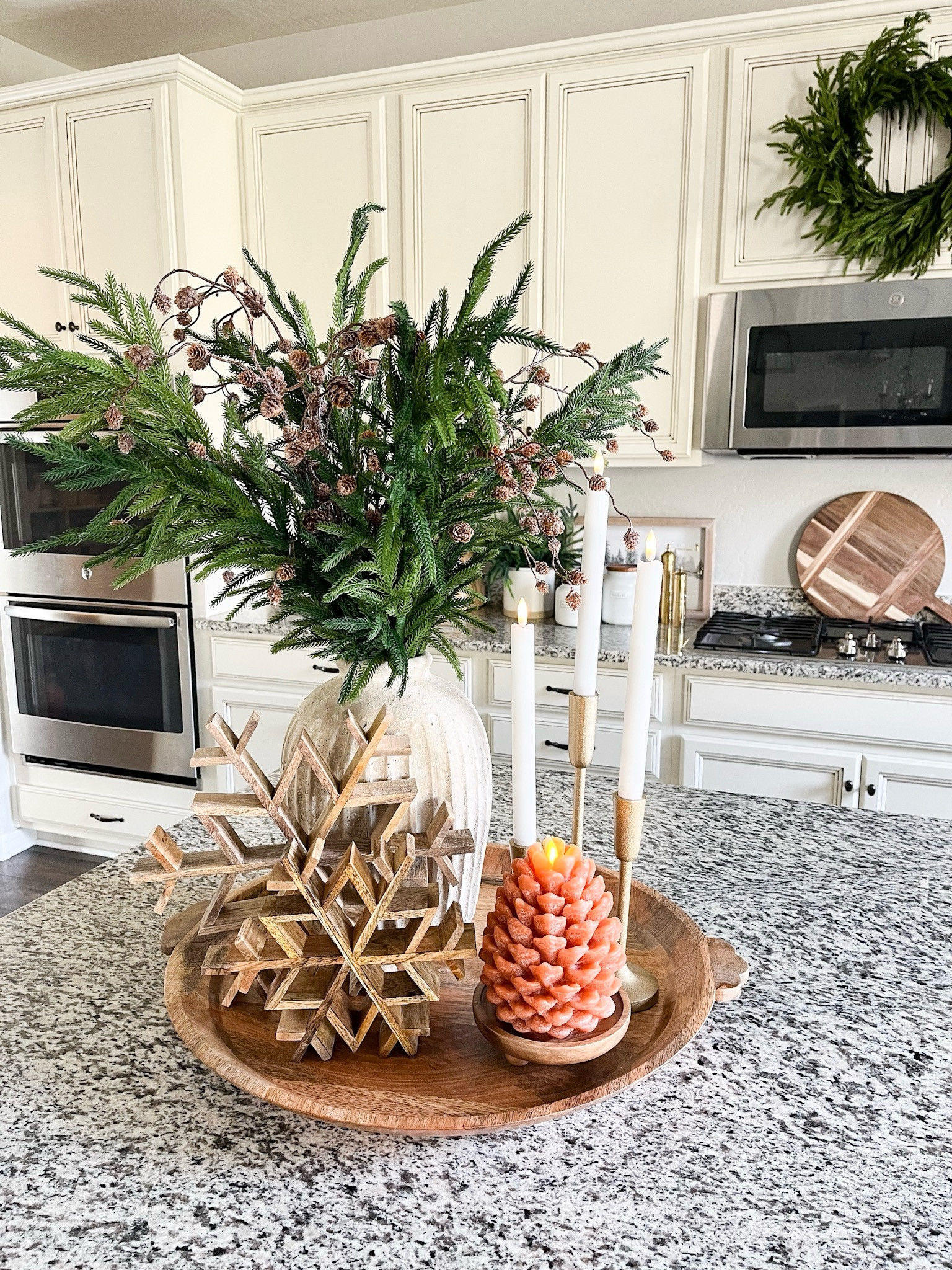 Early winter / Christmas tray styling. This will be perfect for a kitchen counter or centerpiece!
Follow @a.firemans.wife on Instagram for more inspiration.

For reference I'm using 4 of the 36 inch Norfolk stems and 4 of the pinecone stems

Round wood tray | gold candlesticks | flameless taper candles | wood snowflakes | Weathered
Handcrafted Terracotta
Vase | snowy pinecone stem | Luminara Pinecone
Flameless Candle | Small
Wooden Riser Wooden
Pedestal