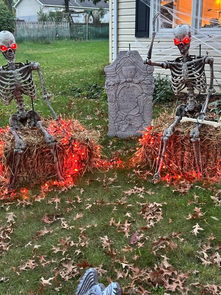Outdoor Halloween decorations with lights, tombstones, and skeletons. 

#LTKHalloween
