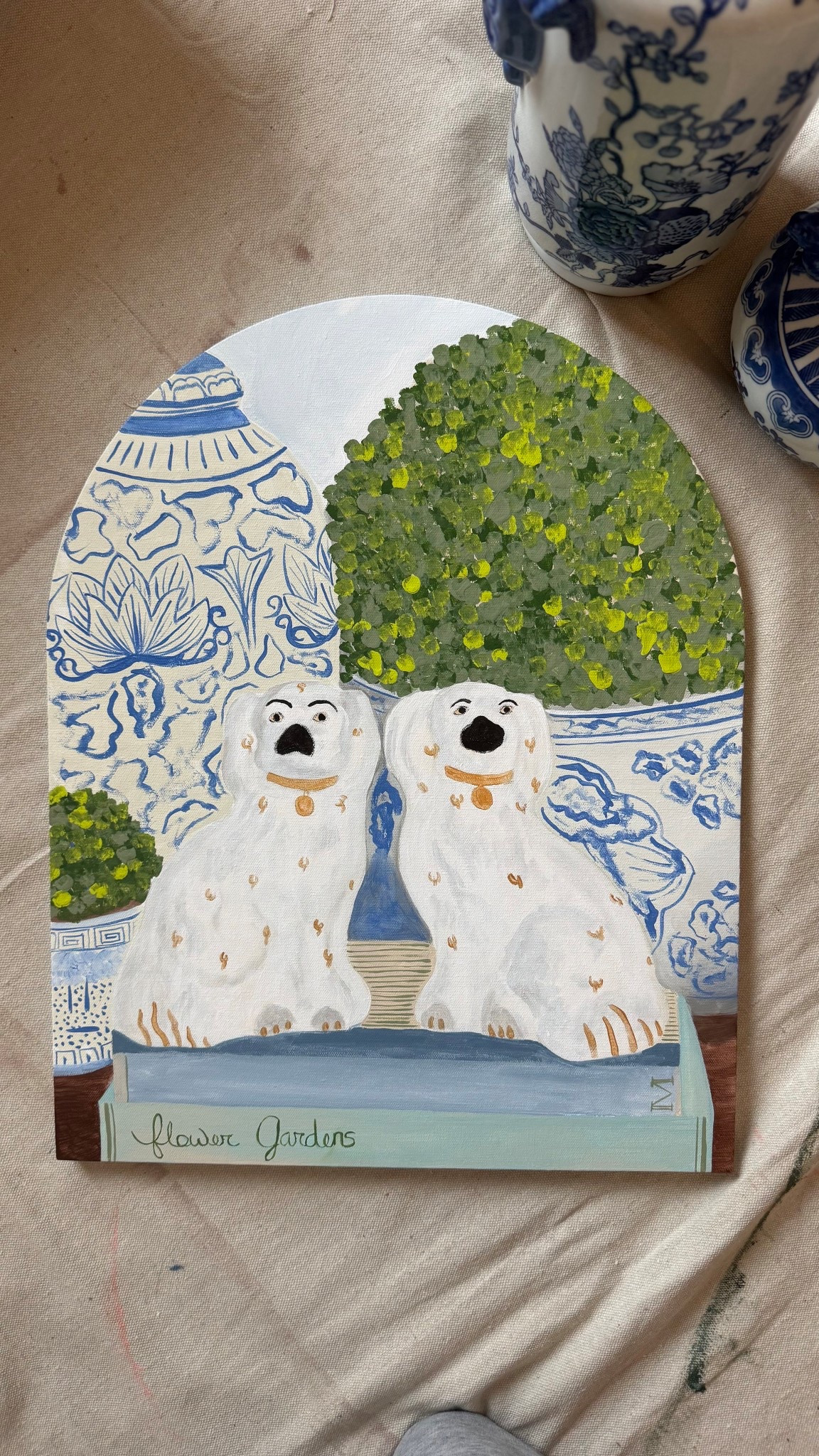 Layering blue and white pottery with botanical garden books for an elegant, organic modern feel. As we move into 2026 home trends, the 'collected' look is back. Featuring original acrylic art by Malea Gordon Home. Perfect for lovers of cottagecore, potager gardens, and classic interior design. 🌿