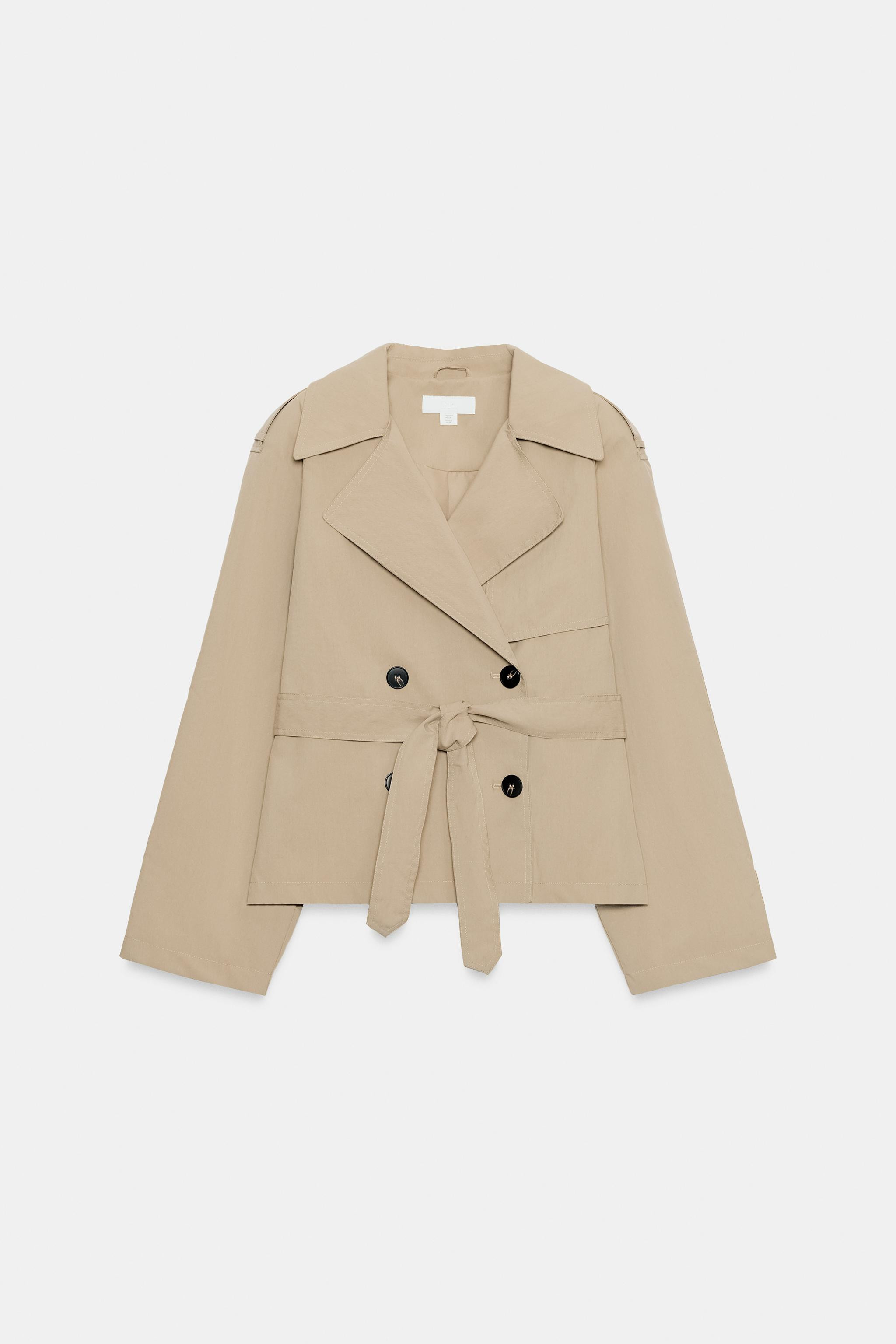 Short trench-style jacket with a lapel collar and long sleeves with shoulder pads. Features tab a... | Zara US