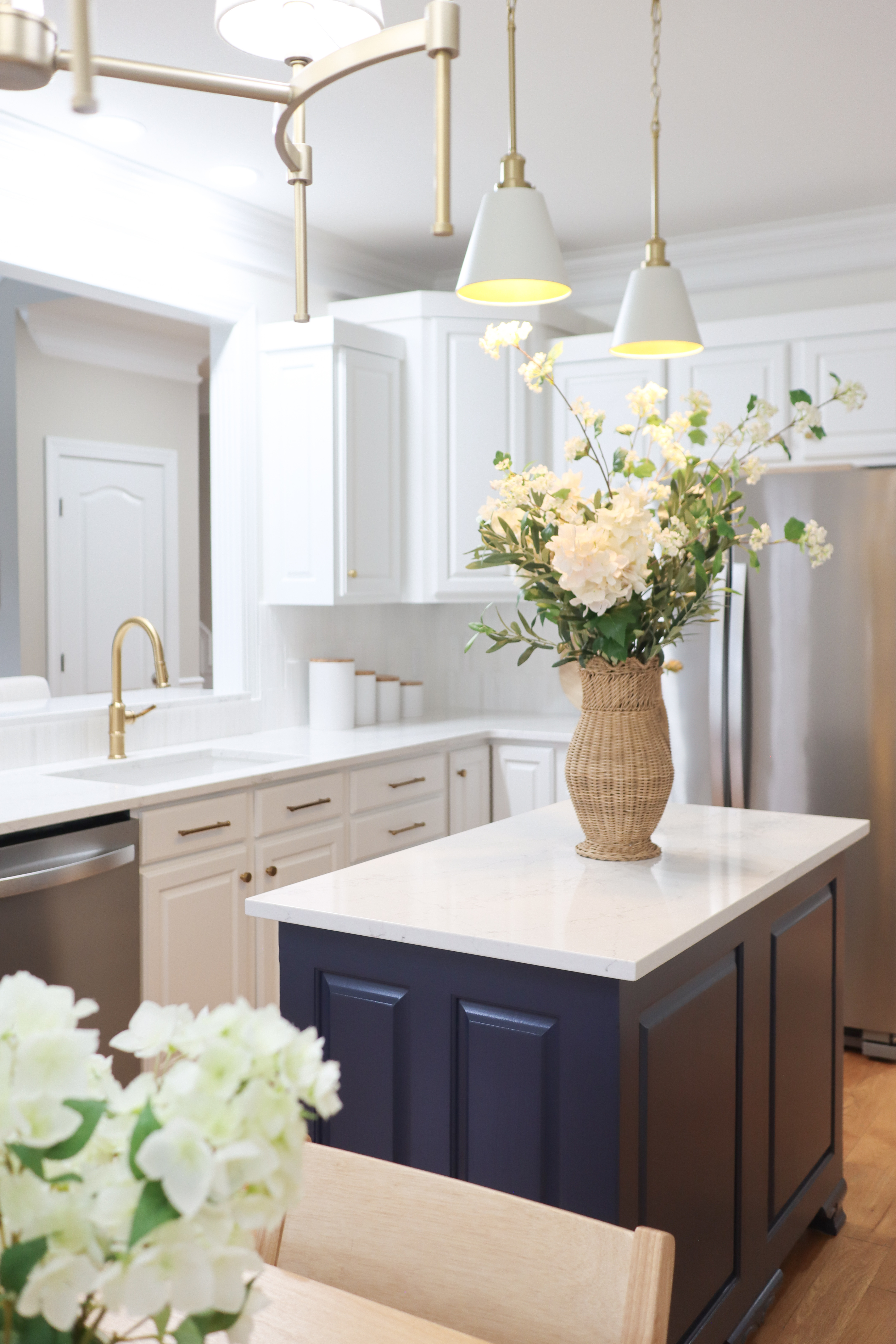 This kitchen transformation was all about taking a dark, heavy space and turning it into something light, fresh, and timeless. We layered crisp white cabinetry and walls, added warm brass hardware for contrast, and anchored the room with a rich navy island. Updated lighting and light wood accents softened the space and brought in warmth.

I’ve linked the key pieces that helped create this bright, elevated look so you can recreate the feel in your own home. 

 #LTKStyle #LTKDecor #InteriorDesign #KitchenRemodel #KitchenInspo #HomeInspo #TimelessDesign #BrightandAiry #CozyHome