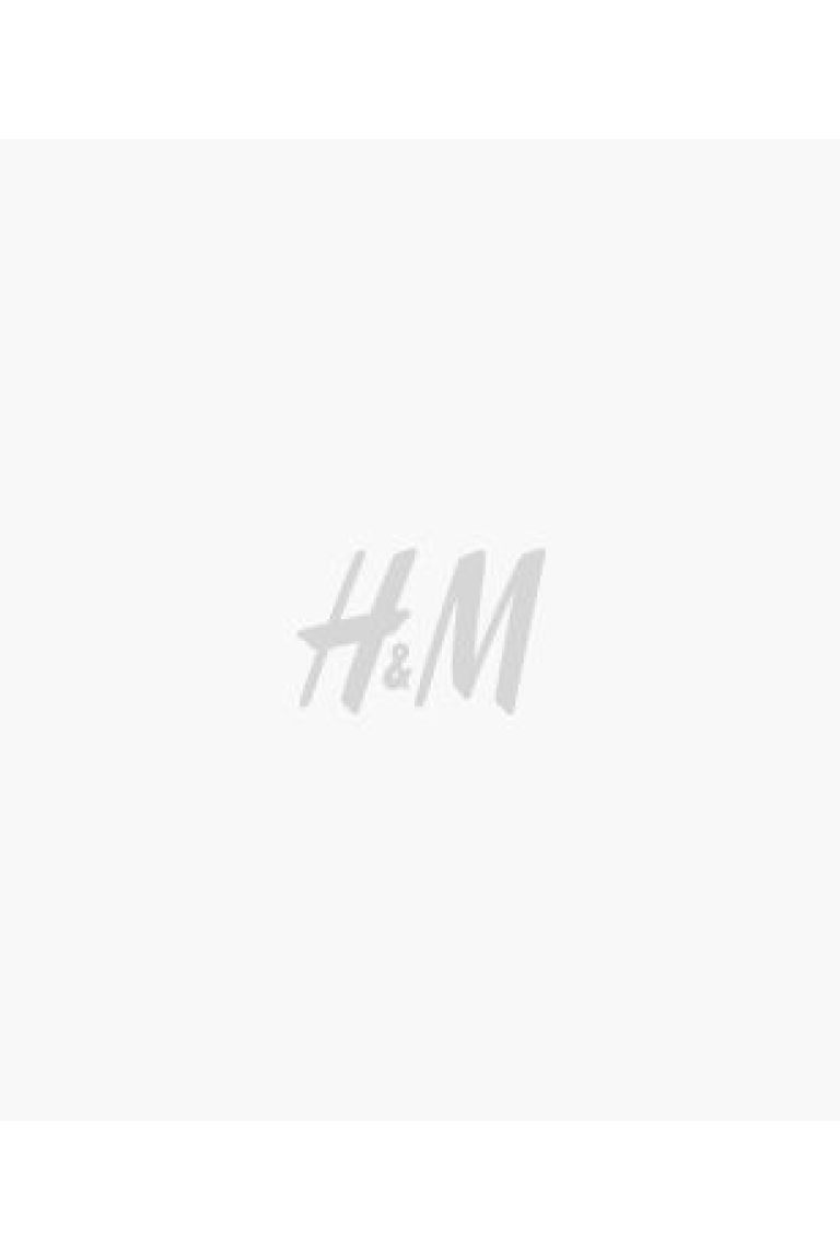 Short skirt in woven fabric. Narrow, elasticized waistband, smocking at upper section, and seam w... | H&M (US + CA)