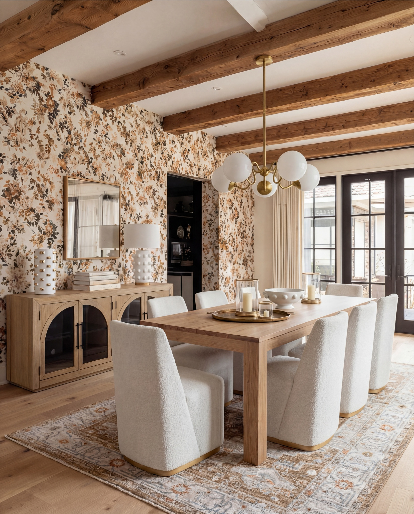 This dining room is giving elevated cozy in the best possible way. The floral wallpaper sets the tone—soft, warm, and a little romantic—while the exposed wood beams add that organic depth everyone wishes their home naturally had.

The shearling-style dining chairs with brass bases? Absolutely obsessed. They bring so much quiet luxury to the space, especially paired with the minimal, clean-lined oak table. And the chandelier… sculptural, modern, and just enough brass to tie the whole palette together.

The sideboard styling is the cherry on top—stacked books, textured ceramics, and a simple mirror that keeps everything feeling light and layered.

Shop the Look:
• Warm oak dining table
• Curved ivory dining chairs (brass base detail)
• Brass + globe statement chandelier
• Soft floral wallpaper (warm neutrals + terracotta)
• Oak sideboard with arched glass doors
• Textured ceramic table lamps + decor
• Neutral vintage-style area rug
• Gold trays + candle set
• White ceramic serving bowl

#LTKHome #LTKSaleAlert #LTKFindsUnder100