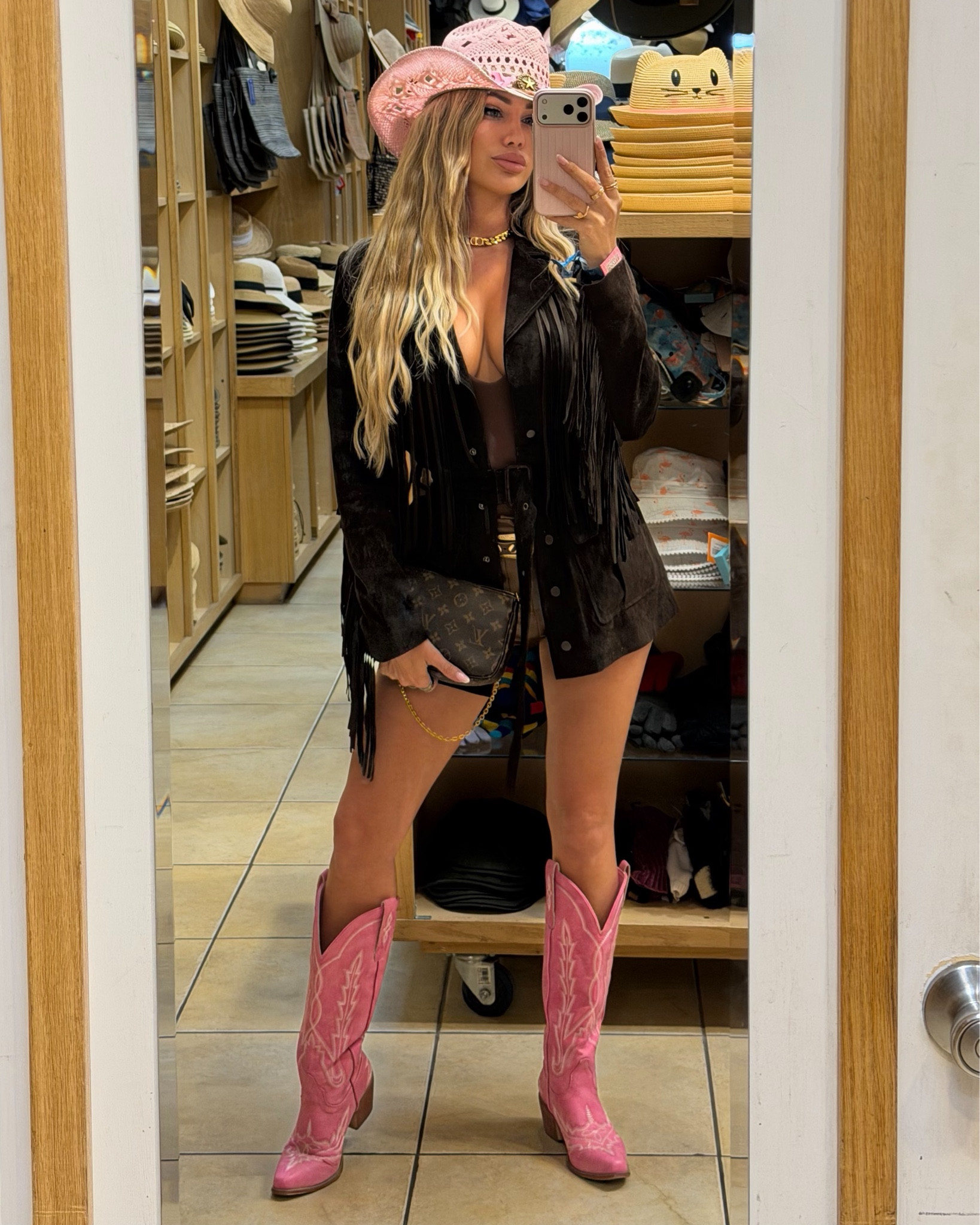 Western cowgirl look styled with a fringe jacket, pink cowboy hat, and matching boots. Paired with a bodysuit, statement belt, and mini bag for a bold, feminine festival outfit.
All details linked here

#LTKFestival #LTKgrwm #LTKdayinmylife