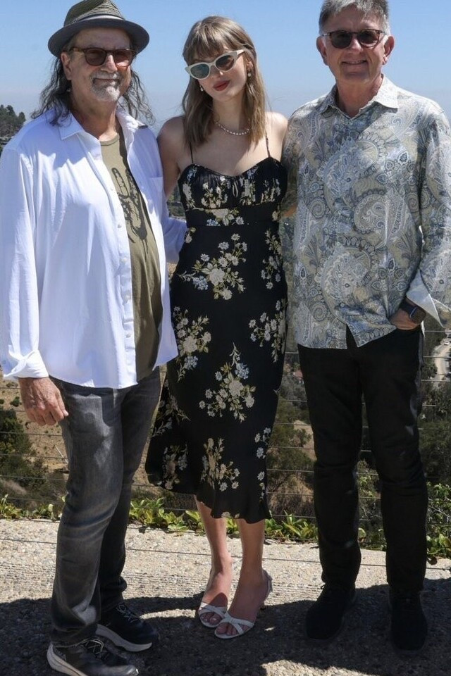 Taylor Swift wearing a black floral dress with pleated bodice with a dainty tie detail defines this slipdress cut in a figure-skimming silhouette from a fluid silk-blend fabric.