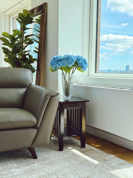 Faux flowers. Added a pop of blue to our neutral living room.  The quality of these flowers is lovely, i bought two for that vase, each comes with three faux hydrangeas. Wood end table with charging station. Crystal vase for flowers 12". Amazon finds for the home.

#LTKHome #LTKFindsUnder50