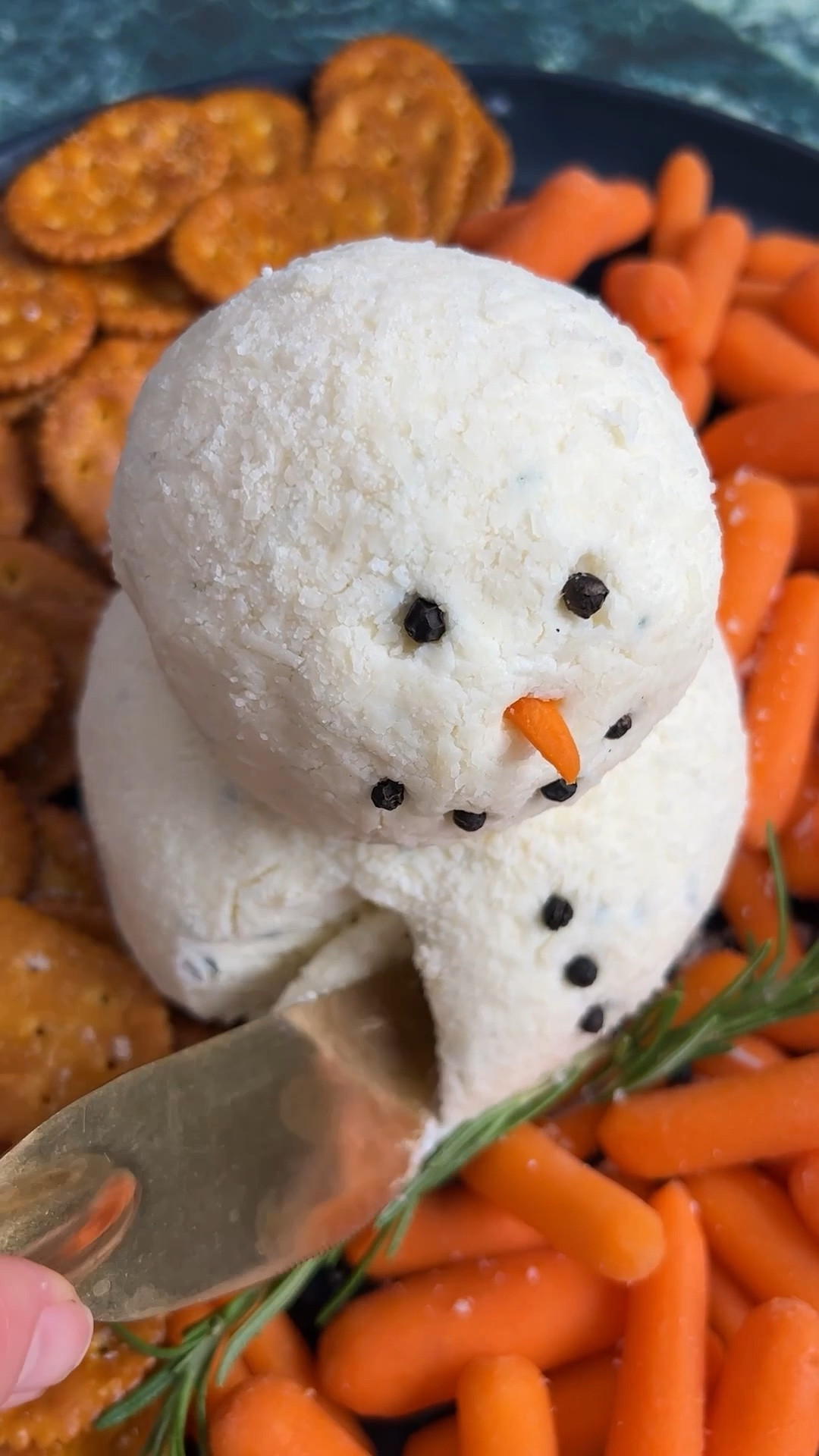 Whether or not the weather outside is frightful, this snowman cheese ball is so very delightful! Bring this adorable app to your holiday party or serve it at home for a festive winter-themed snack. The best part is that it’s super easy! All you have to do is mix up all the cheesy, herby goodness and turn it into the perfect snowperson!

Ingredients
* 16 oz cream cheese softened
* 2 cups Italian cheese blend (SEE NOTE at bottom)
* 1 tsp minced chives
* 1/2 tsp chopped fresh parsley
* 1/4 tsp chopped fresh rosemary
* 1/8 tsp garlic powder
* 2 cups grated Parmesan
* Black peppercorns for garnish
* Baby carrots for serving
* Crackers for serving

Instructions 
* In a medium bowl, combine the cream cheese, Italian cheese blend, chives, parsley, rosemary, and garlic powder. 
* Push the cheese into the center of the bowl and form into a ball. Cover the bowl with plastic wrap and refrigerate for at least one hour or up to overnight. 
* Separate the chilled mixture into two pieces, one bigger than the other. Use your hands to roll them into balls. (Pro tip: Use the plastic wrap while shaping the cheese for less mess and a smoother shape!) Place the Parmesan in a bowl. Working one at a time, roll the cheese balls in the Parmesan (or pat the cheese onto the cheese). 
* Stack the smaller ball on top of the bigger ball. Push the cloves into the cheese balls to make your snowman’s face and buttons. Cut one baby carrot into a small triangle and push into the snowman’s face as a nose. 
* Serve on a platter with crackers and carrots on the side. 
* NOTE: If a bag of Italian Style Shredded Cheese Blend is unavailable, here is a mix, ½ cup shredded mozzarella, ½ cup shredded parmesan, ¼ cup shredded asiago, ¼ cup shredded fontina, ¼ cup shredded provolone. 
https://ainttooproudtomeg.com/snowman-cheese-ball/

#LTKHome #LTKHoliday #LTKSeasonal
