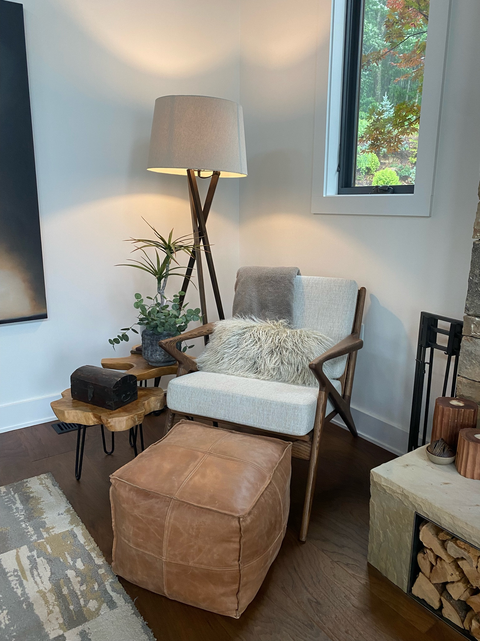 Shop the look!  Texture, contrast and natural color palette pulls this organic modern look together.  Wood accent chairs, table, pot, Tibetan sheep pillow and leather pouf. 