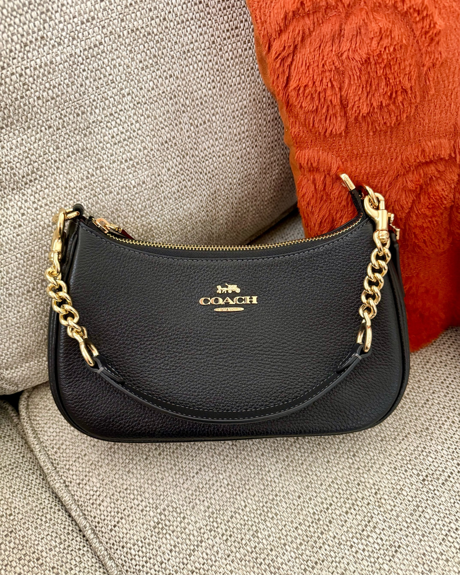 Cute little black purse from Coach. Spacious and not too small. It comes with a detachable handle and a strap that provide flexible options for shoulder or crossbody use. I love the gold details.