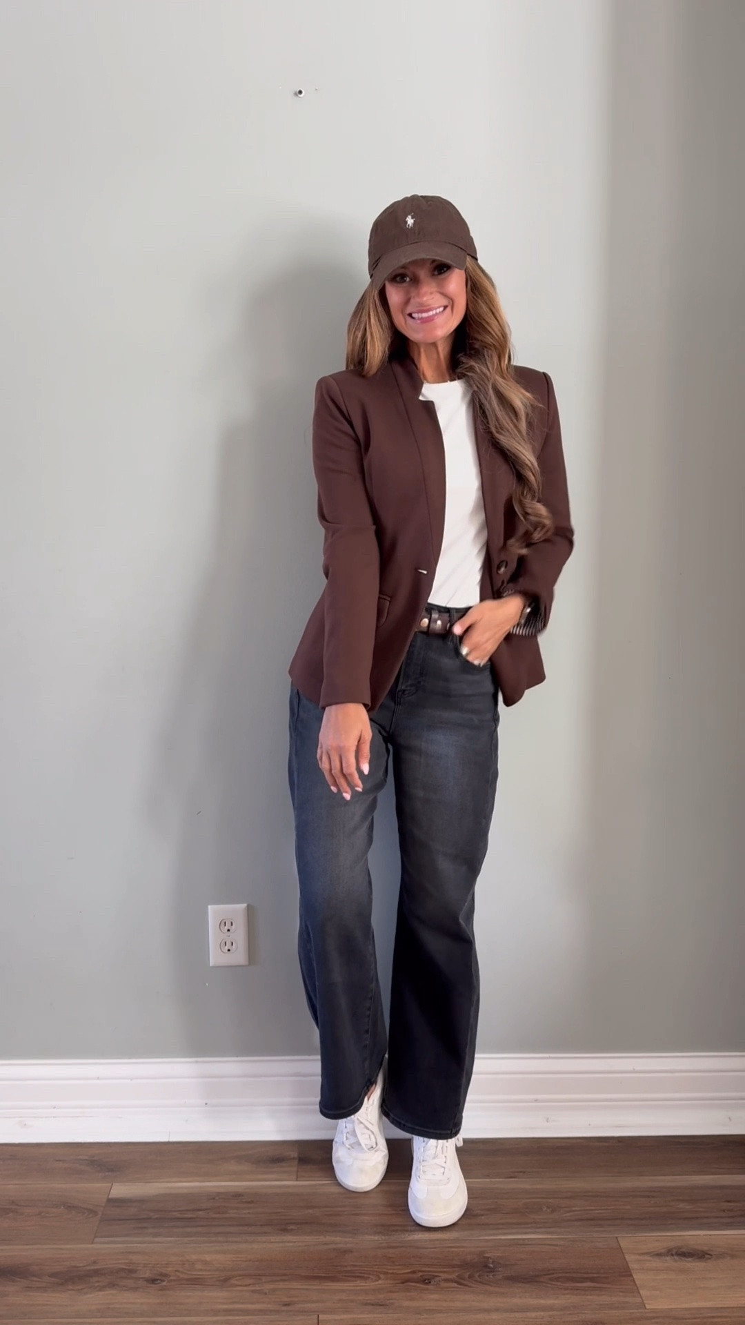 Fall outfit in a brown blazer, white tee, brown cap, grey barrel pants, and sneakers