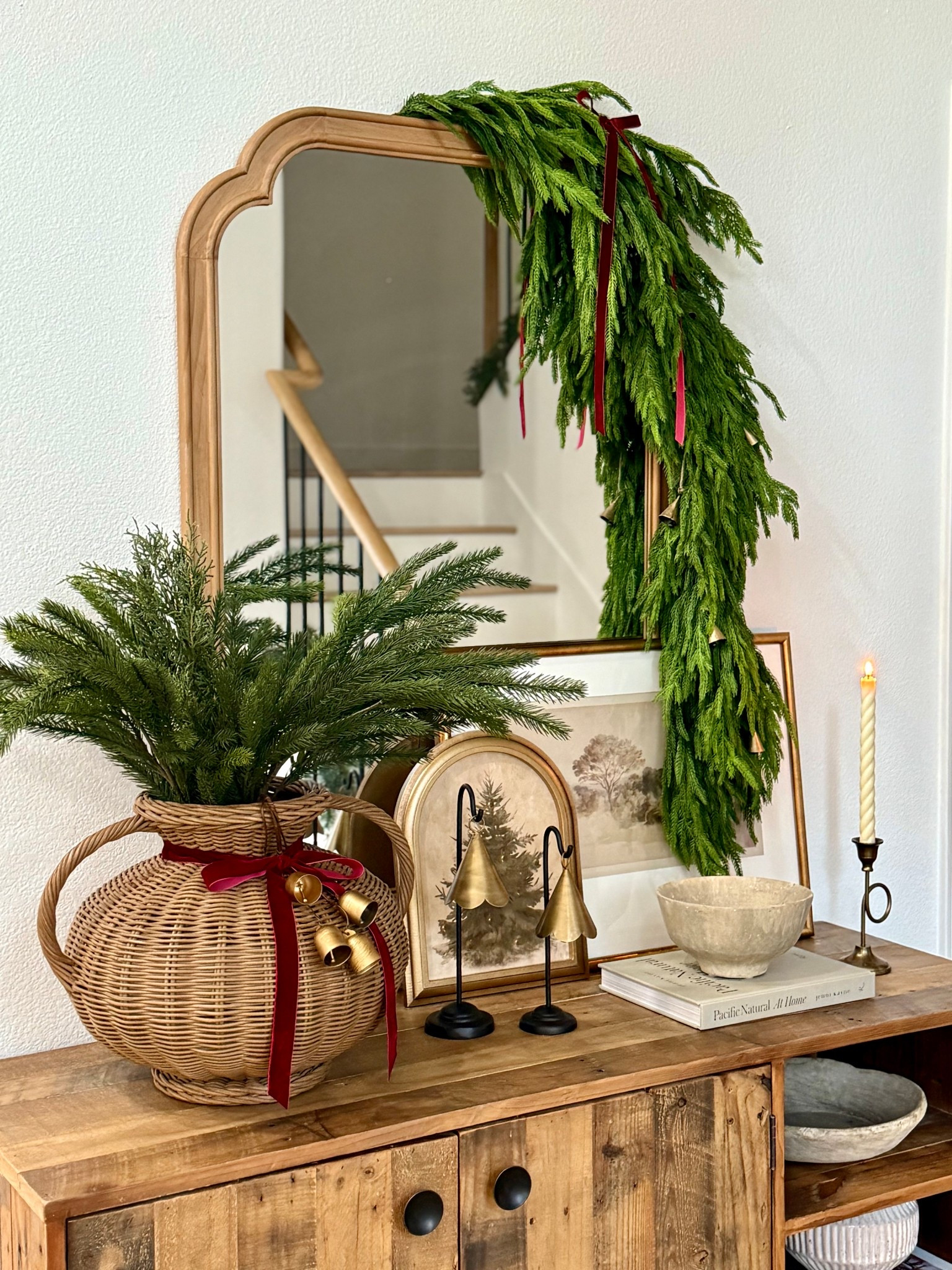 Entryway styled for Christmas. Love this full Norfolk garland from Afloral to decorate a mirror or dining table for Christmas. I styled it with this McGee and Co bell, which is 50% off right now. 

Christmas decor, entryway decor for Christmas  

#LTKHome #LTKSaleAlert #LTKHoliday