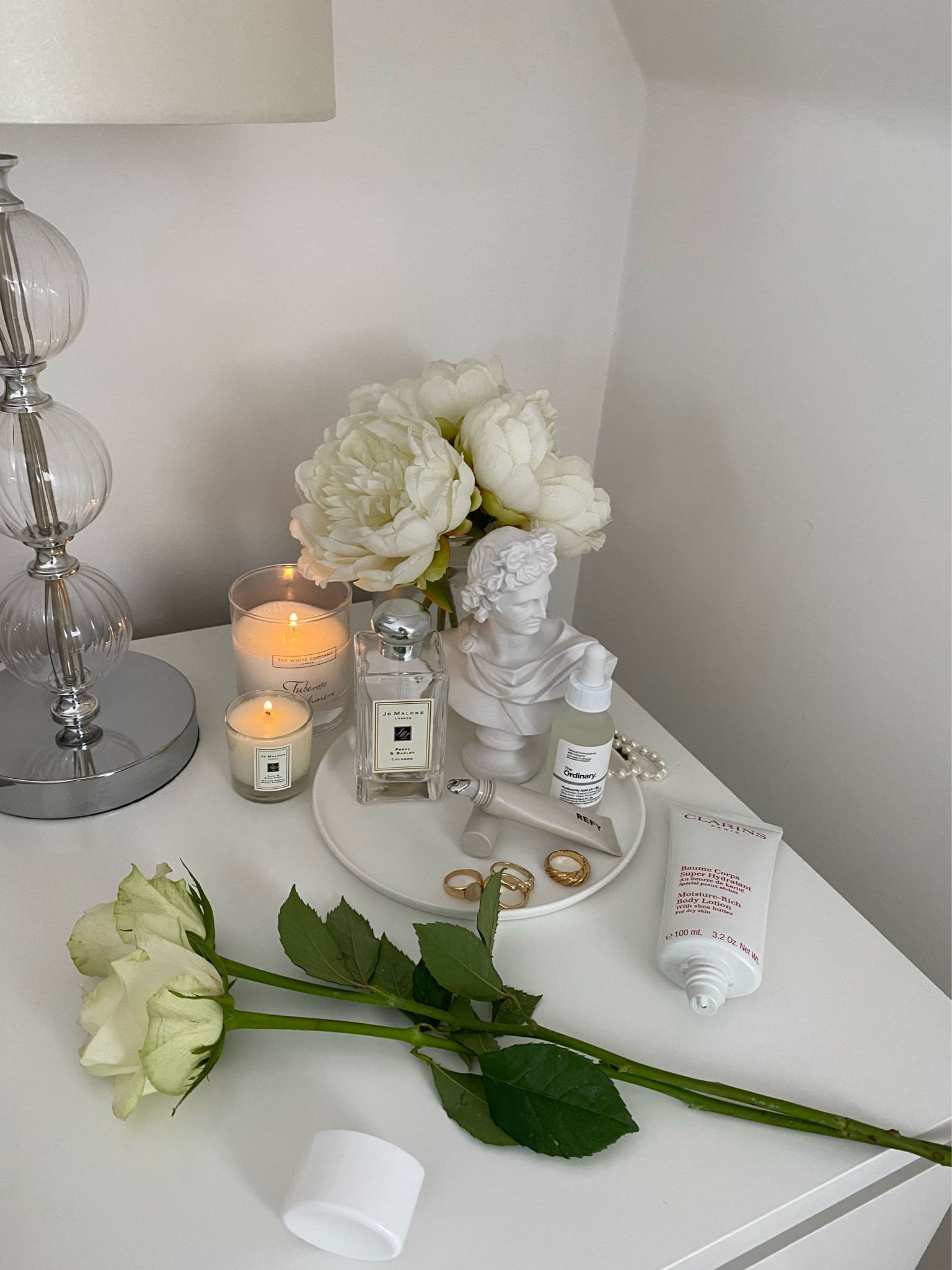 A collection of my favourite things: fragrance, candles, lip gloss and moisturiser 🤍 
- Still life shot of my bedside table
- Greek mythological ‘Apollo’ sculpture bust 
- Gold rings and pearl VW necklace 
- White roses from M&S

#LTKbeauty #LTKeurope #LTKhome