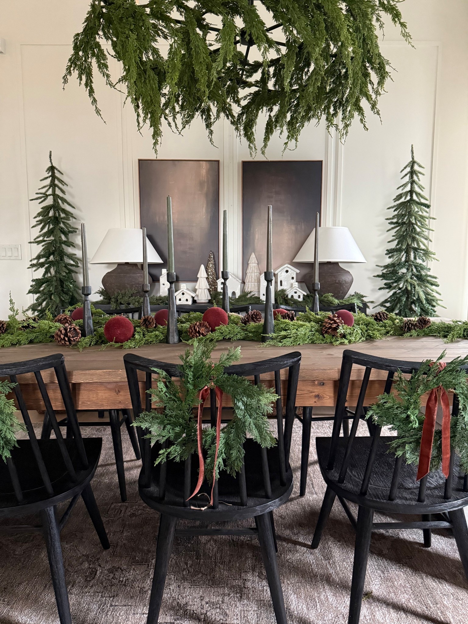 Holiday dining room.. moody, earthy and organic.
Lots of cedar greenery, pinecones, mini wreaths, velvet ribbon.. it’s all in the details. 
Extra drama with the draping cedar in the chandelier 🤎

#LTKHome #LTKSeasonal #LTKHoliday