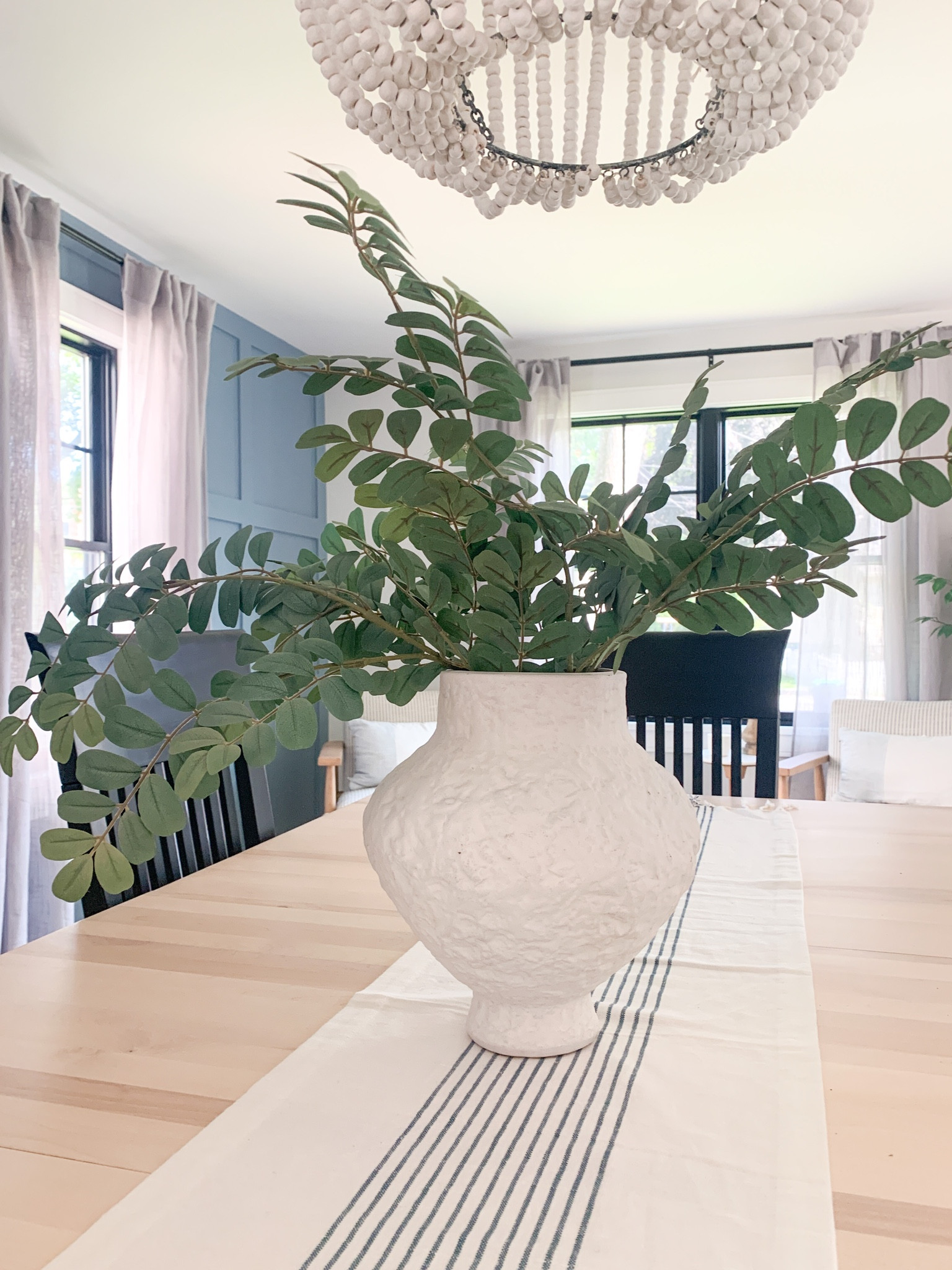 White vase with faux greenery stems. White blue stripes hearth hand magnolia table runner in my dining room. Beaded chandelier. Organic modern, Scandinavian interior design.

#LTKFind #LTKunder50 #LTKhome
