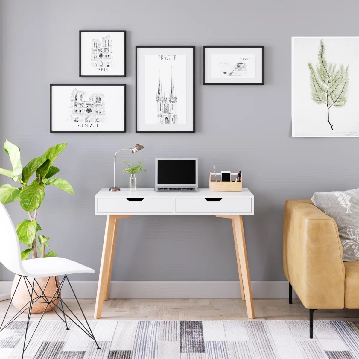 A bright and simple home office setup with a clean white desk and warm wood legs that keep the space feeling calm and modern. The wall art adds a soft gallery touch while the tan armchair brings warmth to the room. Love how the rug, chair, and little plant pull everything together with a balanced neutral palette. #homeofficedecor #desksetupideas #neutraldecor #modernworkspace