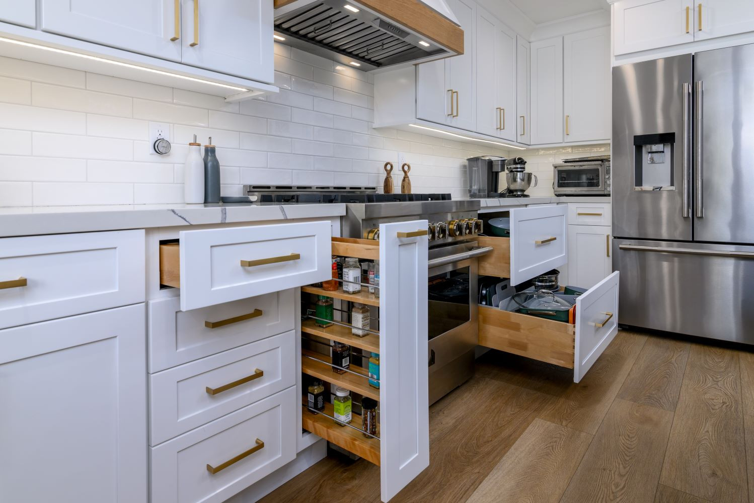 This kitchen is all about smart storage and thoughtful design! The range wall features a custom hood with white oak banding, adding warmth to the space. To the left, a spice pull-out keeps essentials within reach, while on the right, deep drawers store pots and pans effortlessly. A functional and beautiful setup for any home chef!  

 #LTKHome