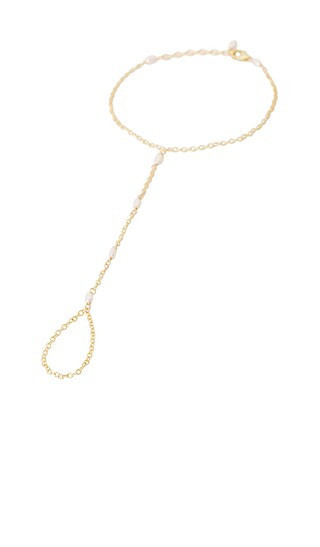 NAiiA Sophia Pearl Hand Chain in Metallic Gold. | Revolve Clothing (Global)