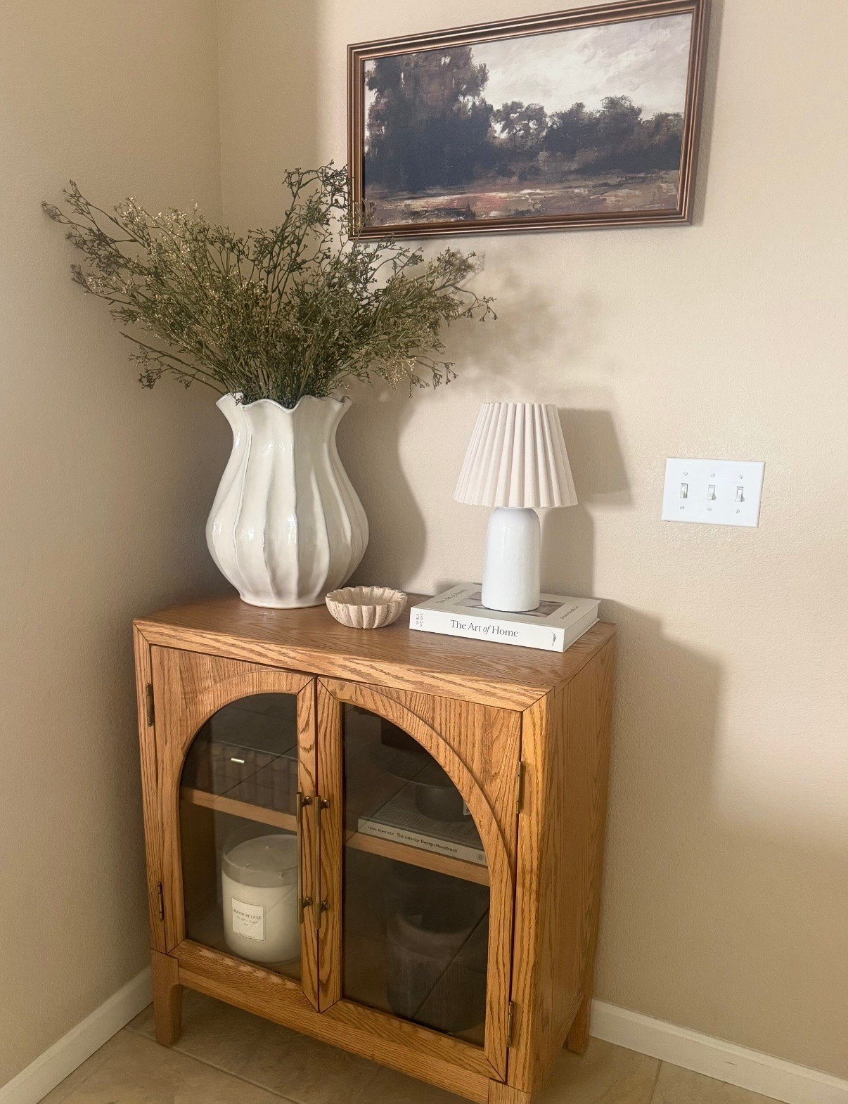 ✨ little corner styling refresh and honestly loving how warm + cozy this area feels now 🤍

this cabinet ended up being one of those pieces that makes decorating SO easy because it adds storage while still looking elevated

styled it with:
✔ oversized neutral vase + stems
✔ soft pleated lamp
✔ coffee table book
✔ warm wood tones + organic textures

simple styling like this always makes a home feel more designer and pulled together without needing a ton of decor ✨

#LTKHome #LTKSaleAlert