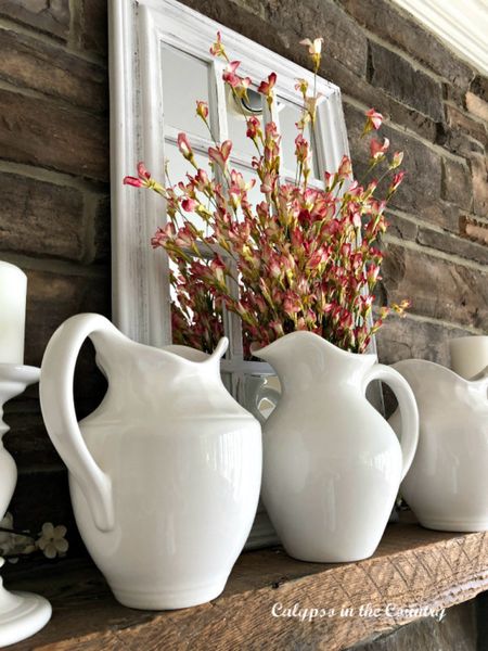 Spring mantel decorating ideas.  Simple white pitchers and spring flowers in front of a white window pane mirror.

#ltkspring #ltkmanteldecor

#LTKhome #LTKSeasonal #LTKstyletip