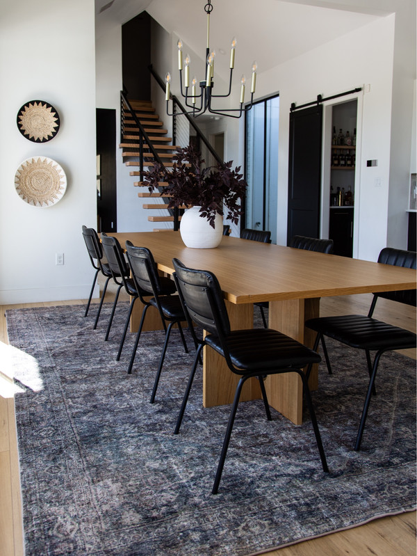 This dining space is layered with cozy fall textures and a grounding vintage-style rug.