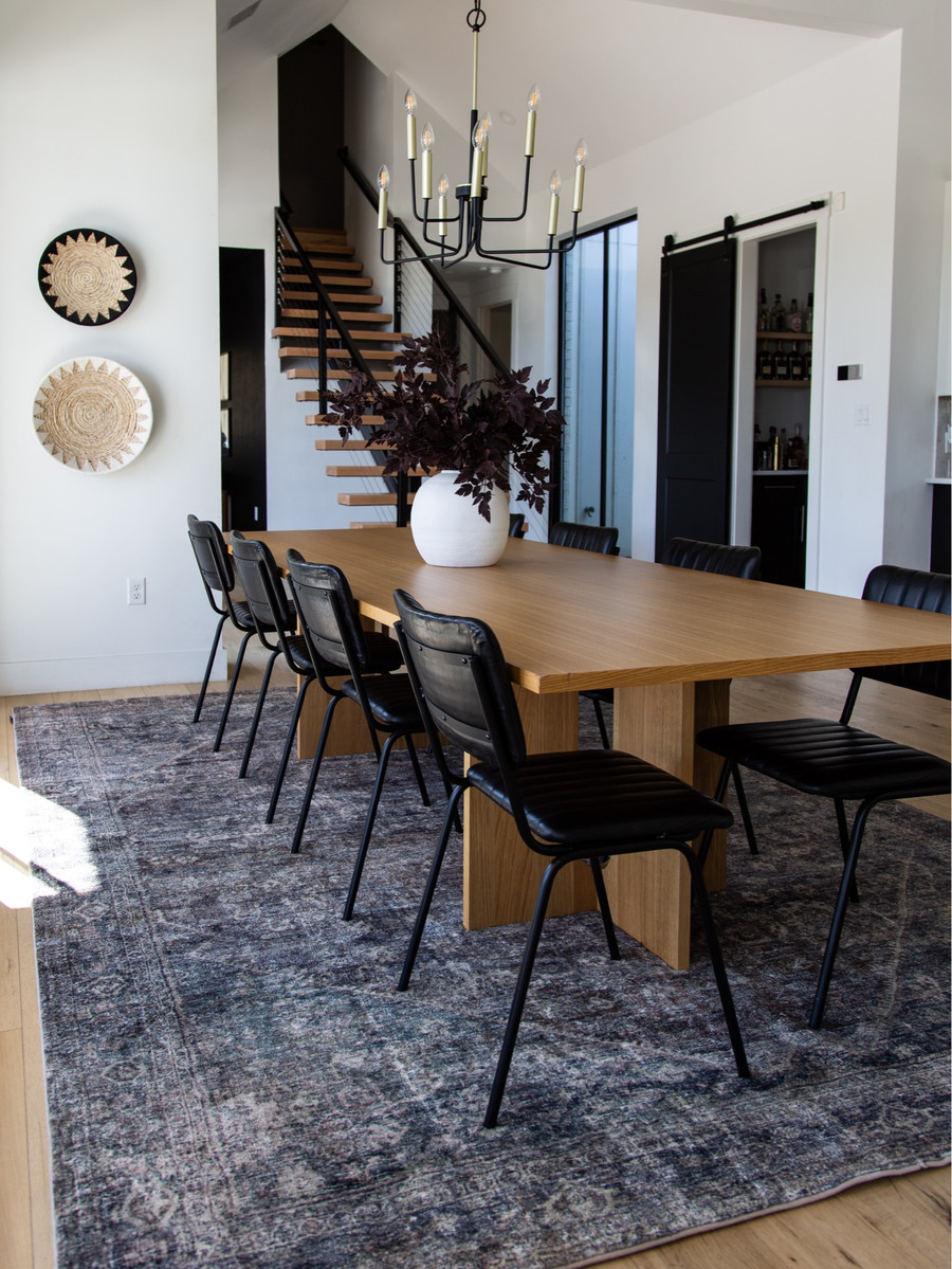 This dining space is layered with cozy fall textures and a grounding vintage-style rug.