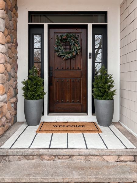 Spring front door . I like to keep it simple with a layered rug, faux shrubs and a beautiful wreath 

#LTKstyletip #LTKhome #LTKSeasonal