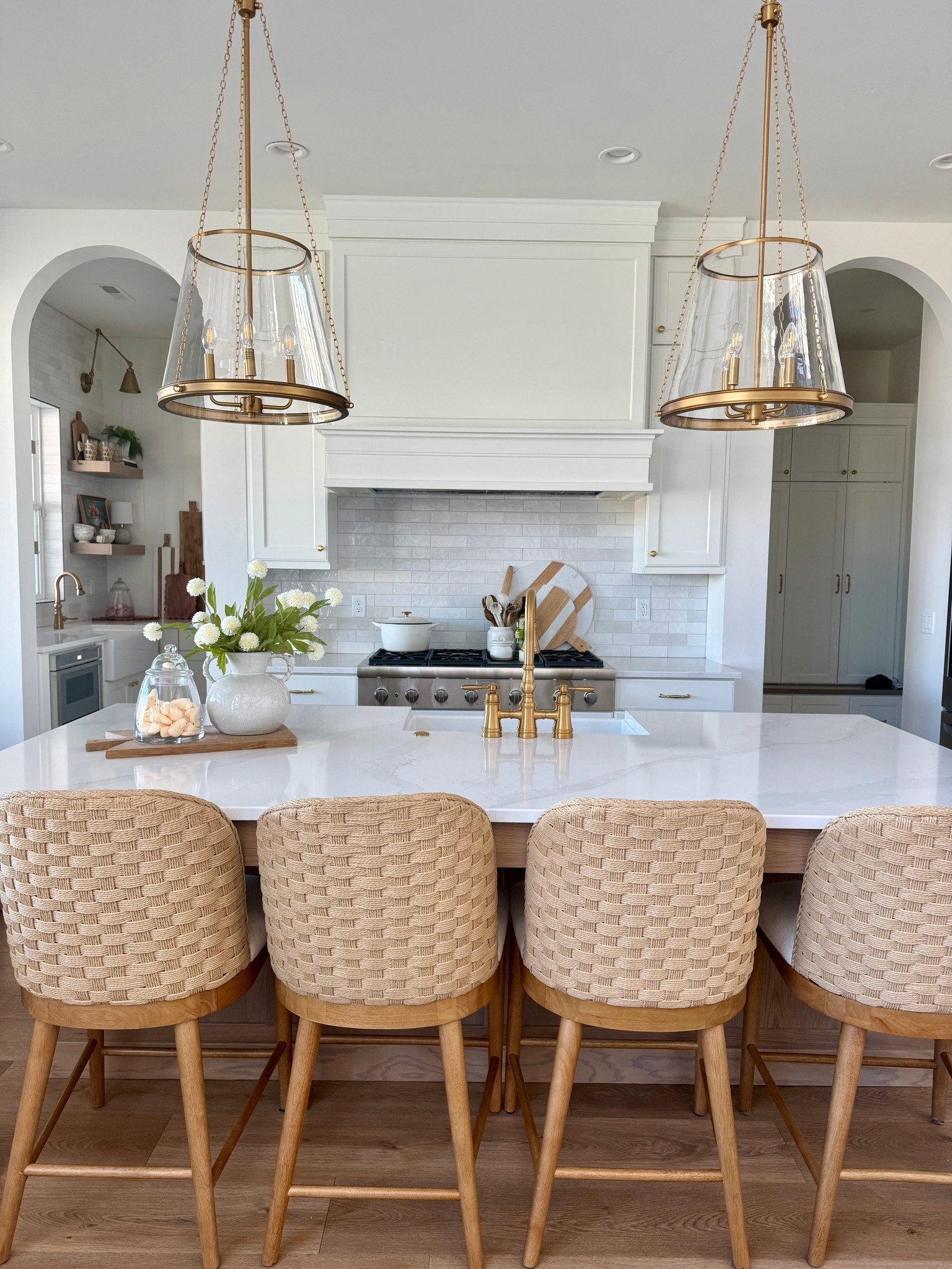 We love a white kitchen! Mixing textures is what makes a space feel layered and warm.
Woven stools, warm wood floors, soft white cabinetry, and a little brass to tie it all together. 

#LTKHome
