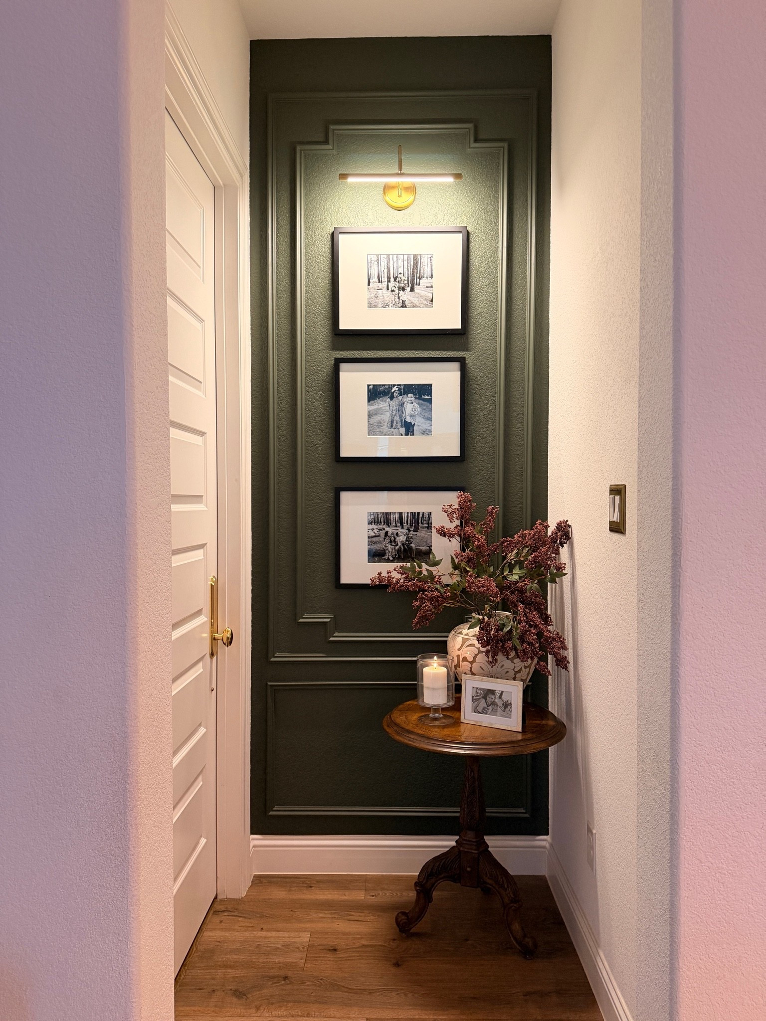 Moody hallway decor, hallway inspiration, dark green wall, accent wall, picture frame molding, wall molding, gallery wall, family photo wall, picture light, brass lighting, vintage side table, pedestal table, traditional home decor, transitional home, collected home, cozy hallway, narrow hallway decor, entryway styling, framed family photos, warm wood tones, vintage inspired decor, timeless home style, home decor inspiration, hallway makeover

#LTKHome #LTKSeasonal #LTKSaleAlert