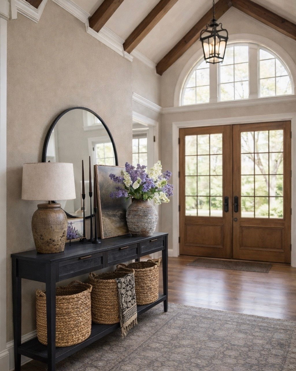 Entryway Console Table Styling with Woven Baskets and Spring Florals

Follow @farmtotablecreations on Instagram for more home finds and styling ideas.

Simple entryway styling that makes a big impact. This black console table paired with woven storage baskets adds warmth and function while keeping the space organized. I layered a large round mirror, neutral artwork, and a textured lamp to create height and balance. The stone vase filled with soft purple and white stems brings the perfect touch of spring while the candlesticks add a little contrast and elegance. Such an easy way to elevate an entryway while still keeping it practical.

#consoletable #entrywaytable #entrywaydecor #baskets #wovenbaskets #entrywaystorage #tablelamp #roundmirror #vase #fauxflowers #candlesticks #area rug

#LTKSaleAlert #LTKHome