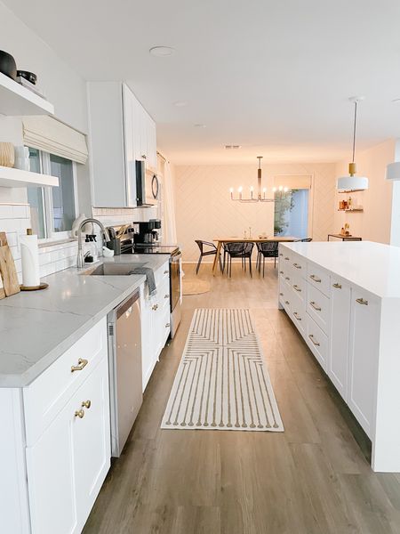 A gorgeous mid-century modern kitchen. Would you believe this rug is washable? The pendant lighting, black chairs, white oak dining table and an island that seats 6 - this kitchen is truly a beautiful space for holiday meals galore!

#ruggable
#whitekitchen
#black chairs
#oakdining
#goldpulls
#modernlighting
#diningroomlight
#lightfixtures


#LTKunder50 #LTKunder100 #LTKhome