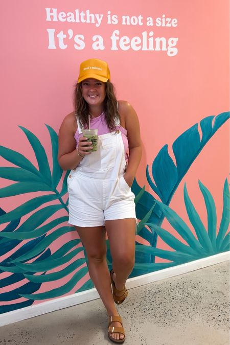 casual vacation outfit 🌞 use code MARLEYDEAL for 10% off my haCham🧢 ✨white denim overalls • high neck tank • trucker hat • Birkenstock Arizona sandals 

#LTKunder50 #LTKtravel #LTKSeasonal