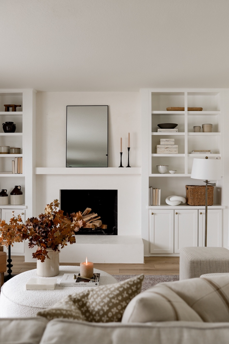 Shop our neutral family room furniture decor! Detouring a gorgeous neutral, performance rug, sleek beige sofa, boucle ottoman, leather chair, and striped Target ottomans. Loving the fall decor this year!