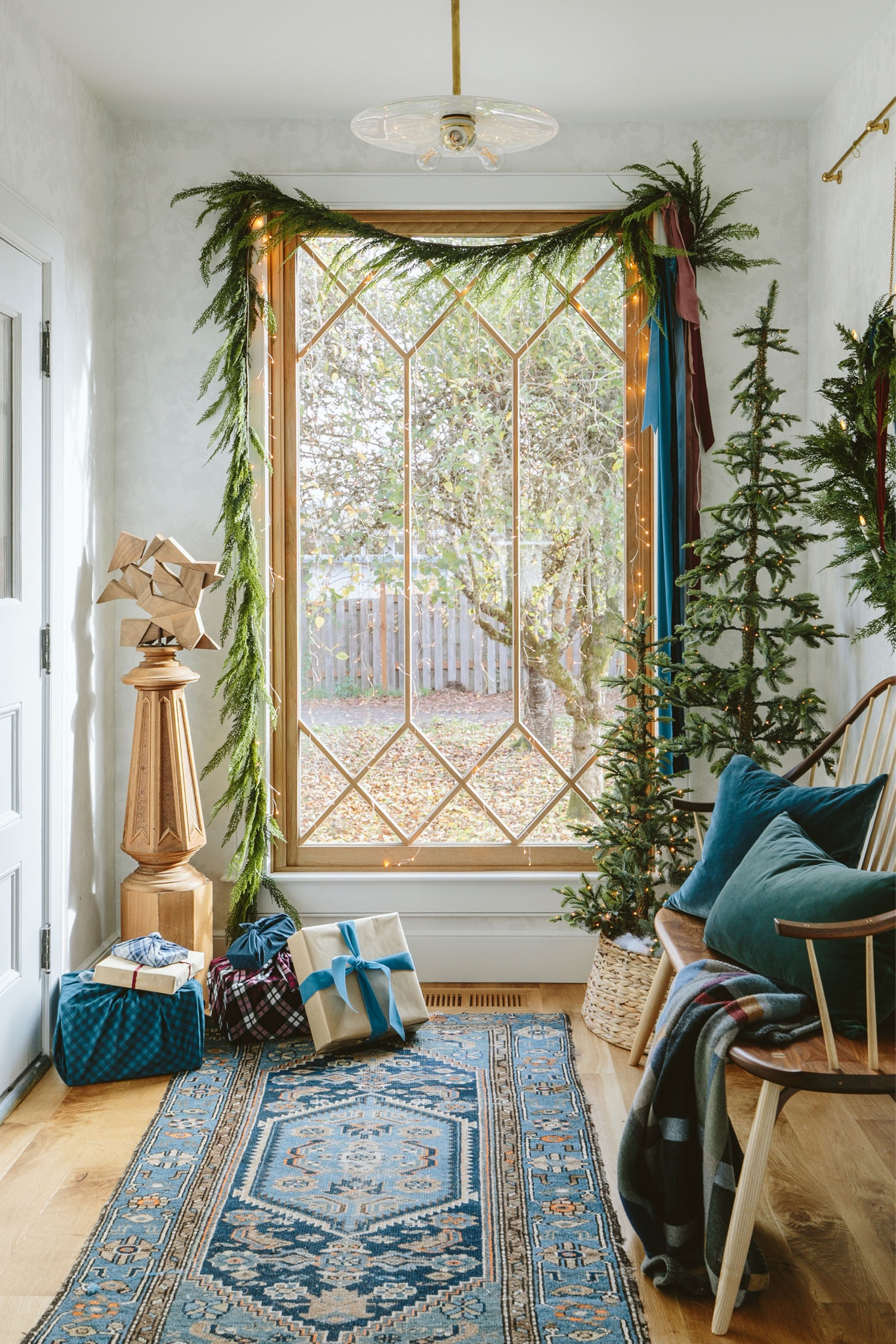 It makes me so happy every time I look over here (that window doesn’t hurt). Last year I bought these plug-in pre-lit alpine trees, and this year I partnered early on some decor from Terrain (the wreath, garland, and clip-on candles – all so good). Then I just added more ribbon/fabric in a loose drape, and put some of my velvet pillows over there. It’s so jewel-toney and yet still feels unabashedly Christmas (IMHO). I also love how the wreath hangs on the gallery rod chain (Pepe & Carols). I haven’t done the front door or outside yet, but this entry feels really good this year.

#LTKHoliday #LTKCyberWeek #LTKhome