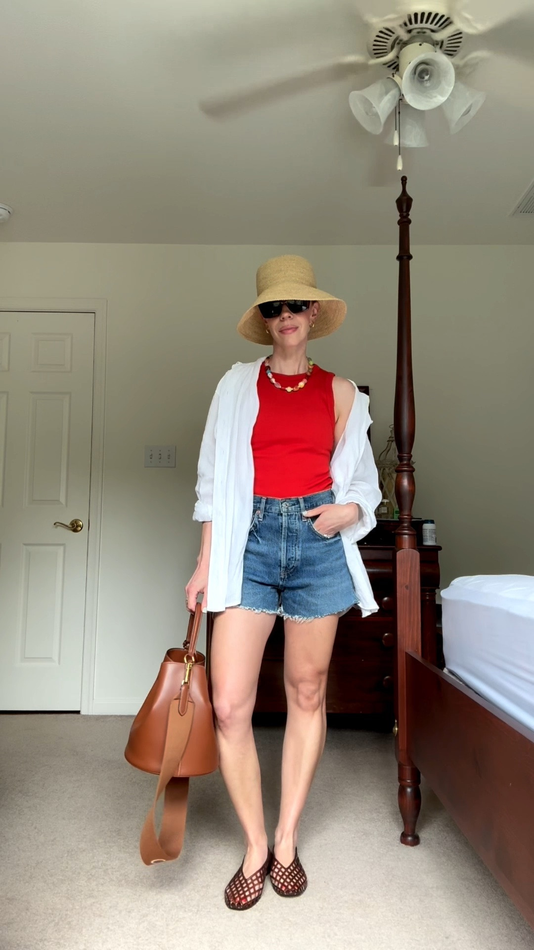 Casual summer outfit with line shirt, red tank, denim cutoff shorts, jelly shoes, beaded necklace, @Janessa Leone straw bucket hat