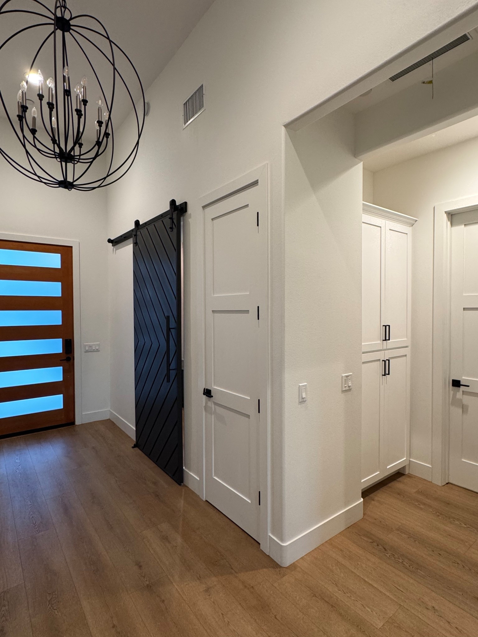 Front door entryway 🤍 

Barn door | black handles | chandelier | light  

#LTKHome #LTKStyleTip