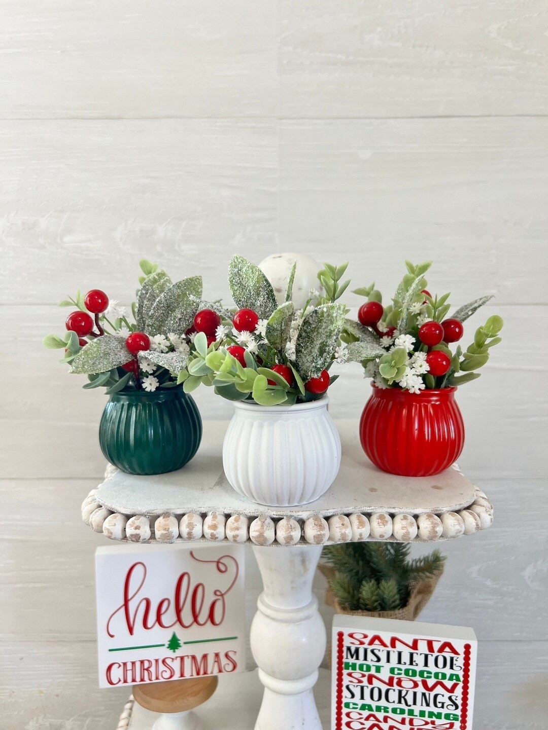 Bring a touch of farmhouse charm to your holiday decor with this adorable mini Christmas arrangement by PinkLizzyDesigns. Each 5-inch glass vase—available in red, green, or white—is filled with a festive mix of faux eucalyptus, sparkly mistletoe, red berries, and white baby’s breath. Perfect for tiered trays, shelves, or small spaces that need a little Christmas cheer, this sweet handmade piece adds cozy, rustic style to any corner of your home. 🎄✨

#FarmhouseChristmas #HolidayDecor #EtsyFinds #MiniArrangement #ChristmasVibes #FestiveHome #TieredTrayDecor #RusticHoliday #HandmadeChristmas #PinkLizzyDesigns

#LTKSeasonal #LTKHome #LTKFindsUnder50