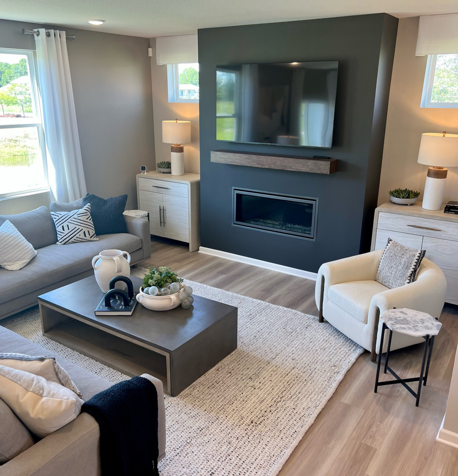 Model home, black painted fireplace, sherwin Williams, accent chair, rug, living room, bedroom, office, family room, loft, lamp, credenza, shelf, coffee table, sofa, couch, coffee table books, pottery, jug, vase, pottery barn, burke decor, Walmart, lamps plus, accent pillows

#LTKunder100 #LTKsalealert #LTKhome