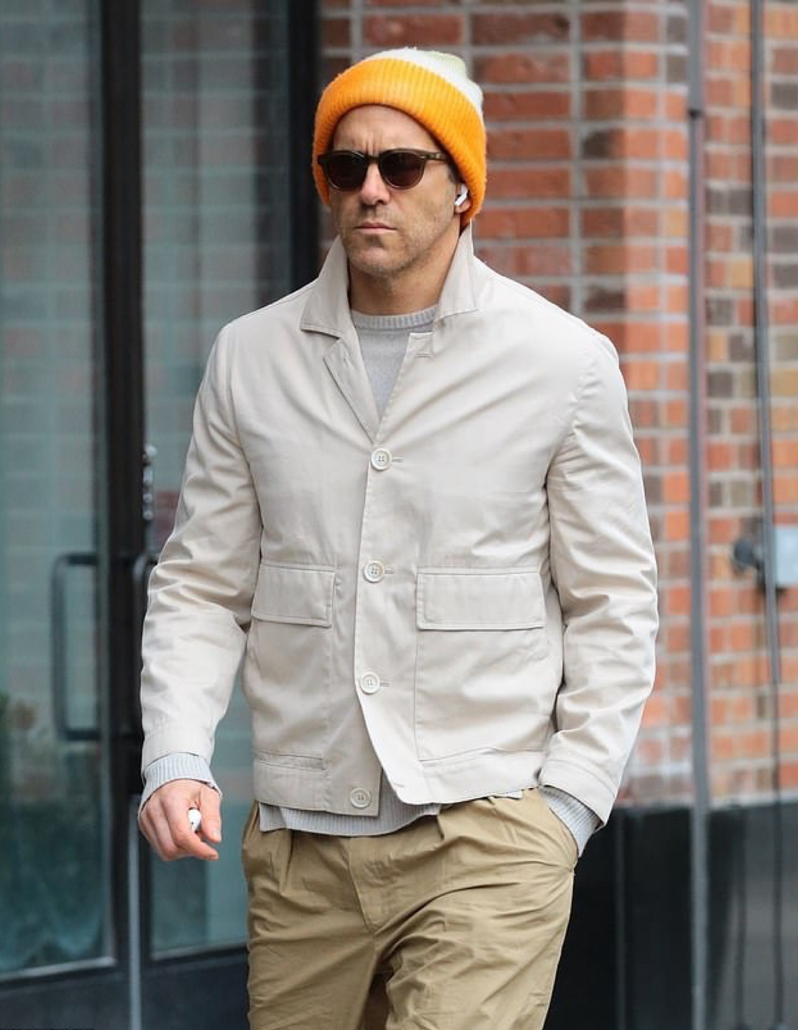 Ryan Reynolds walking around NYC wearing a ribbed-knit orange cashmere beanie, olive green and rose sunglasses, a cashmere biker jumper sweater, and beige jacket  

#LTKStyleTip #LTKMens
